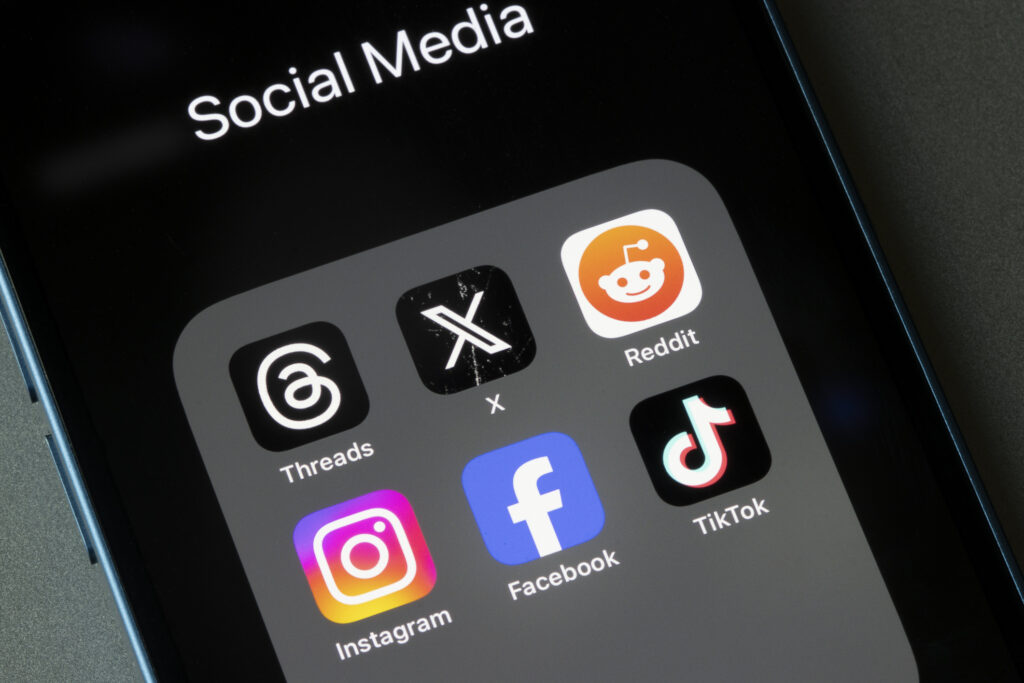 Assorted social media apps, including Threads, X, Reddit, Instagram, Facebook, and TikTok, are seen on an iPhone.